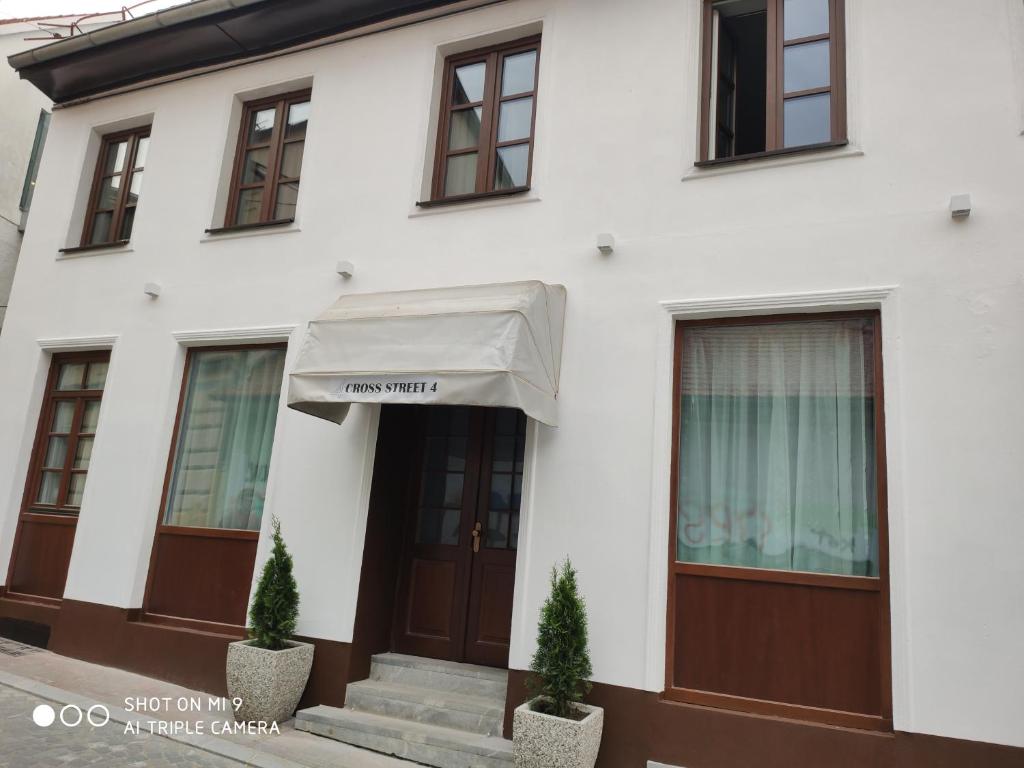 a white building with awning on the front of it at Aparthotel Cross Street 4 in Ljubljana