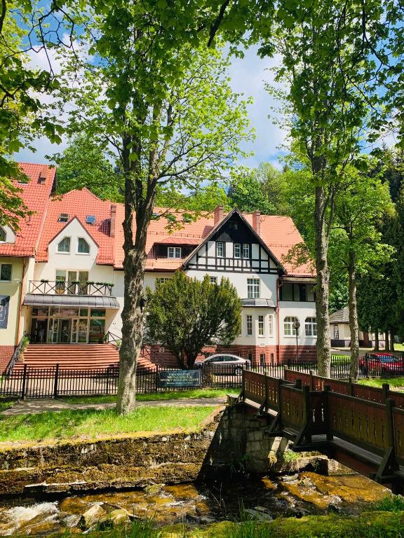 a bridge over a river in front of buildings at Willa Jarzębina in Duszniki Zdrój