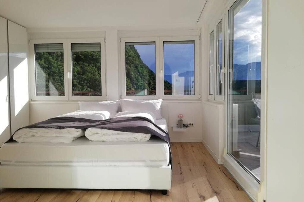 - une chambre blanche avec des fenêtres et un lit dans l'établissement Apartment Mathilda, à Bolzano