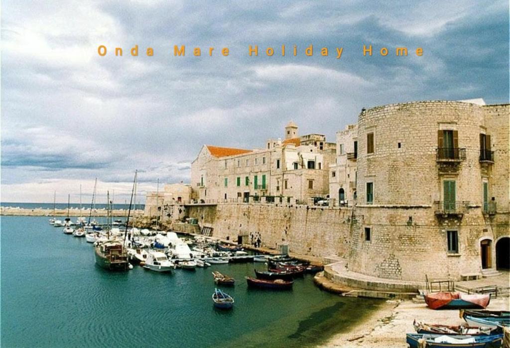 un grupo de barcos en un puerto al lado de un edificio en ONDA MARE Holiday Home, en Giovinazzo