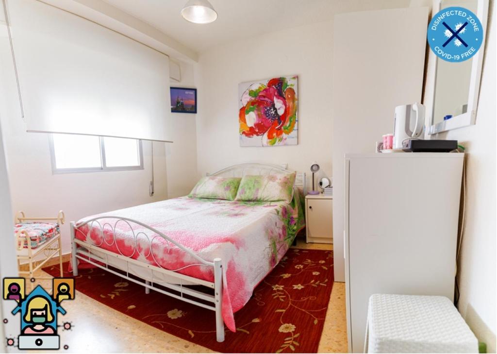 Dormitorio pequeño con cama y nevera en Hospedaje Gandia Ciudad, en Gandía