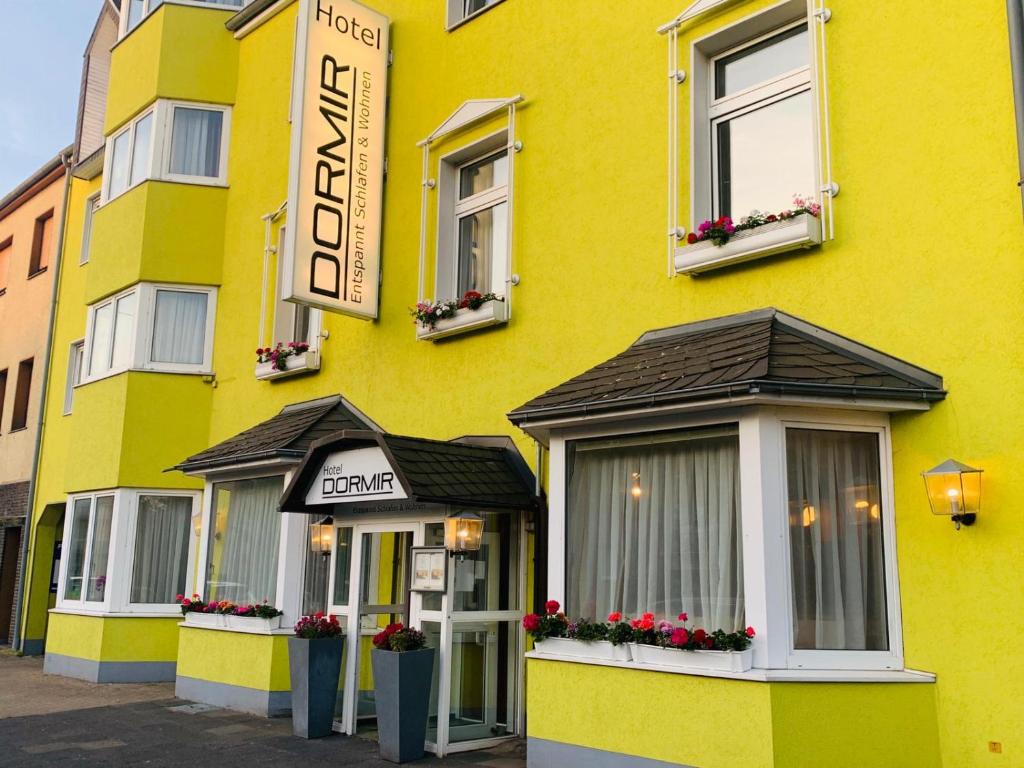 a yellow building with a sign on it at Hotel Dormir in Moers