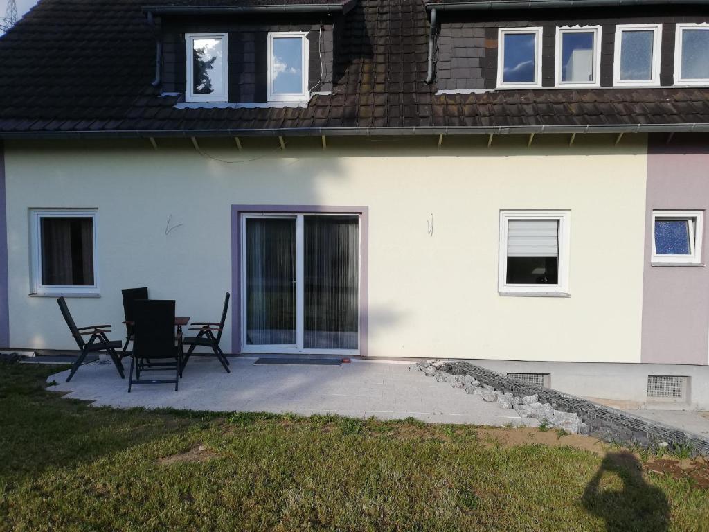 uma casa branca com duas cadeiras e um pátio em Ferienwohnung Waldeck am Edersee em Waldeck