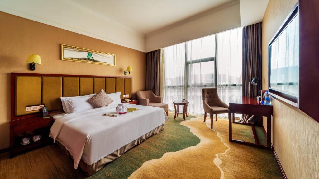 長沙市にあるChangsha Jiaxing Innの大きなベッドとデスクが備わるホテルルームです。