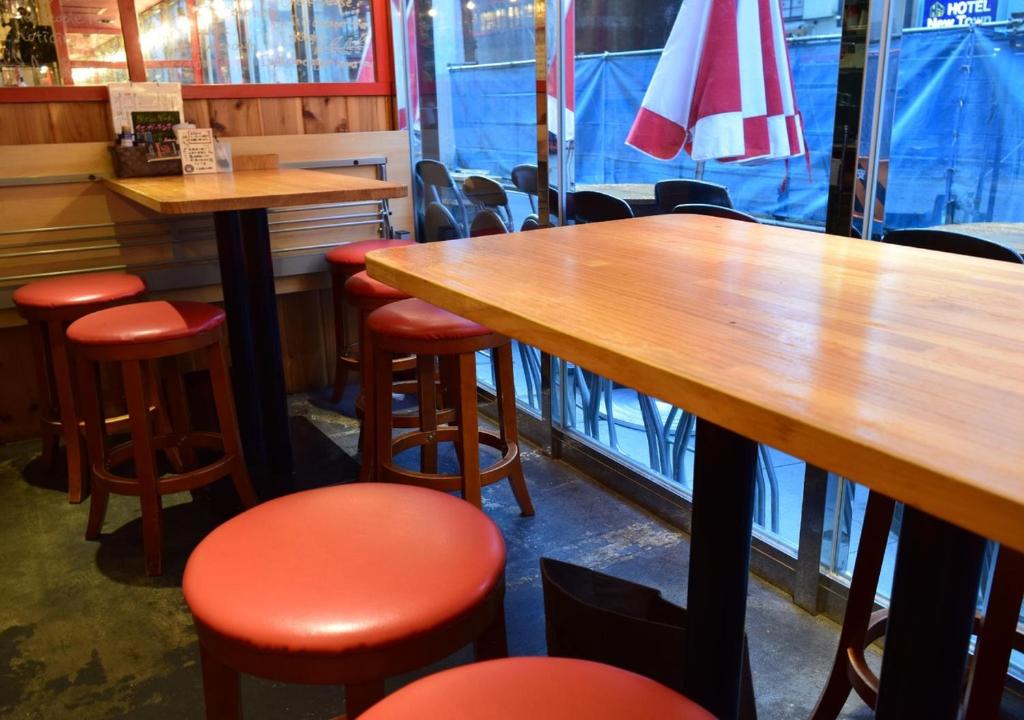 a restaurant with wooden tables and red stools at APA Hotel Akihabara Ekimae in Tokyo