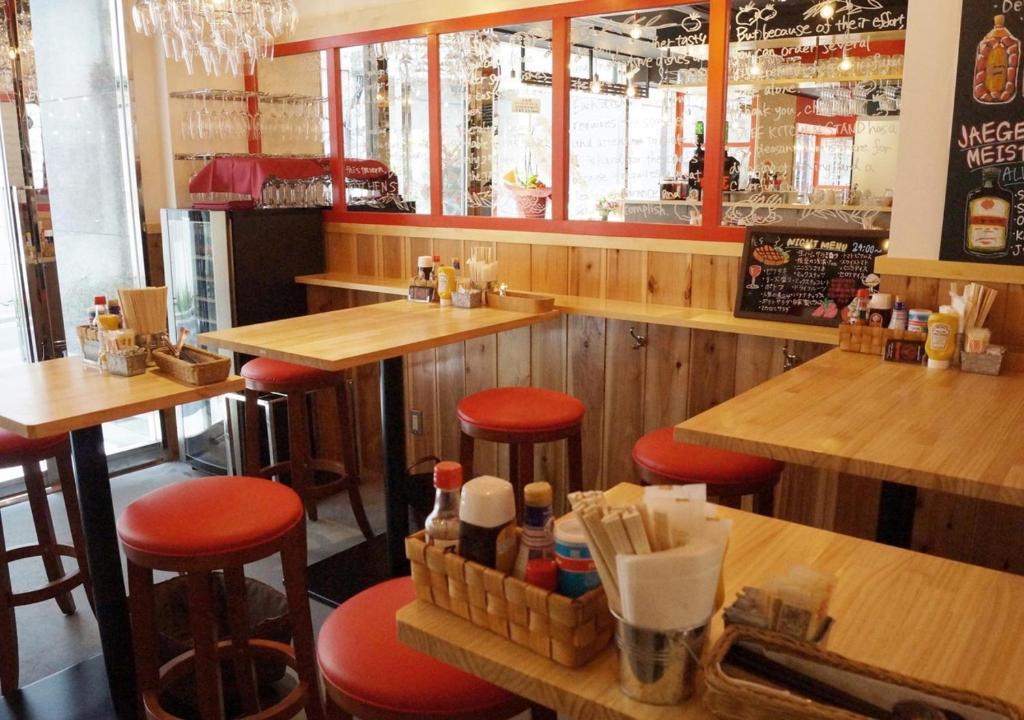 a restaurant with wooden tables and bar stools at APA Hotel Akihabara Ekimae in Tokyo