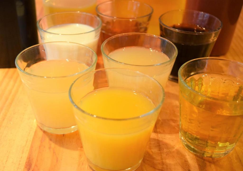 a group of glasses of orange juice on a wooden table at APA Hotel Akihabara Ekimae in Tokyo