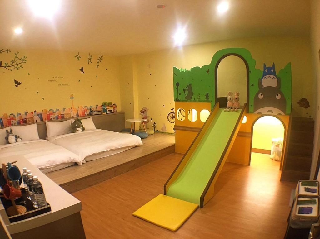 a bedroom with a bed and a slide in it at Mulin B&B in Hengchun