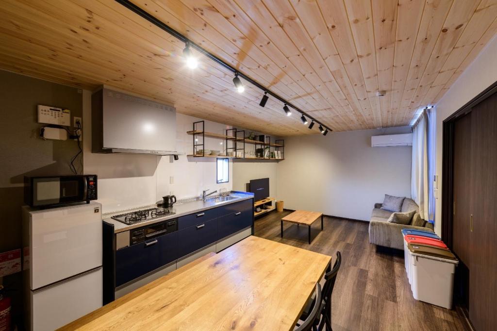 una cucina e un soggiorno con soffitto in legno di Rakuten STAY HOUSE x WILL STYLE Sasebo 103 a Sasebo
