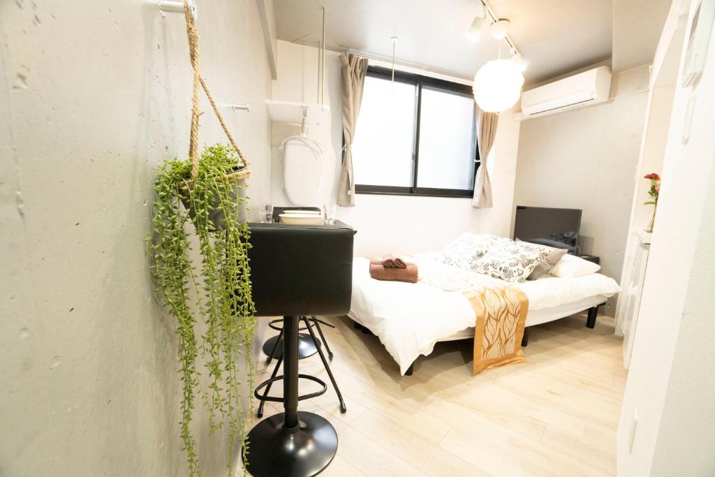 um pequeno quarto com uma cama e uma janela em Hill Side Terrace Hiroo Shibuya 102 em Tóquio