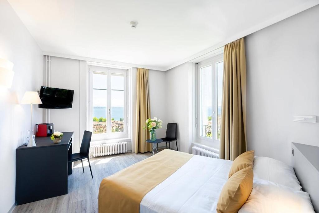 Postel nebo postele na pokoji v ubytování Hôtel Alpes & Lac
