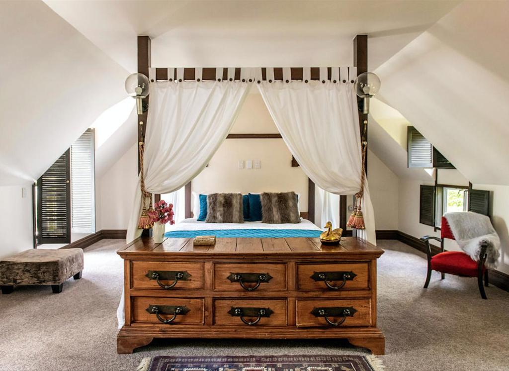 馬斯特頓的住宿－The 540 Lodge，一间卧室配有一张带木制梳妆台的天蓬床