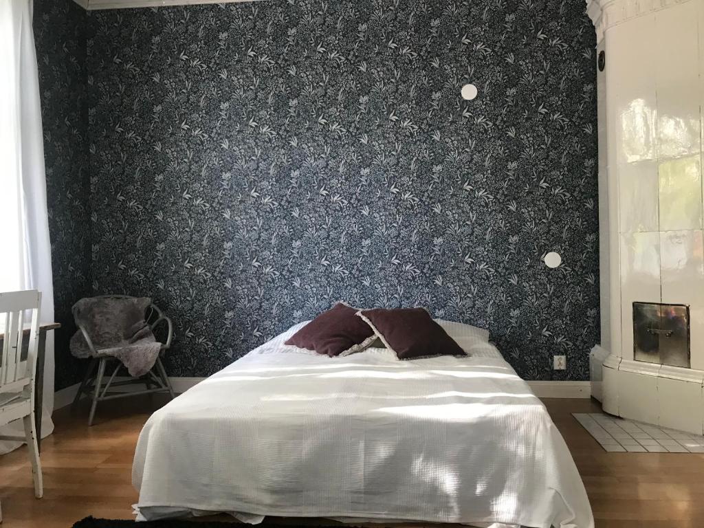 een slaapkamer met een bed en een zwarte muur bij Willa Strand in Kristiinankaupunki
