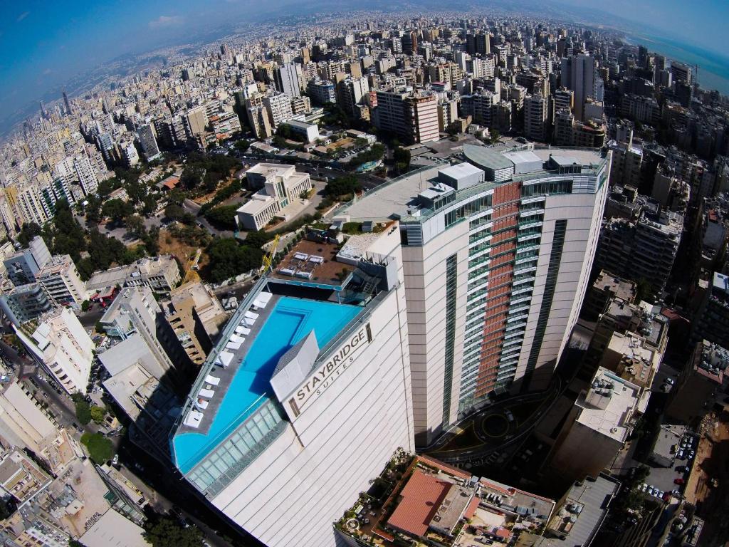 Staybridge Suites Beirut, an IHG Hotel في بيروت: اطلالة جوية على مبنى طويل في مدينة
