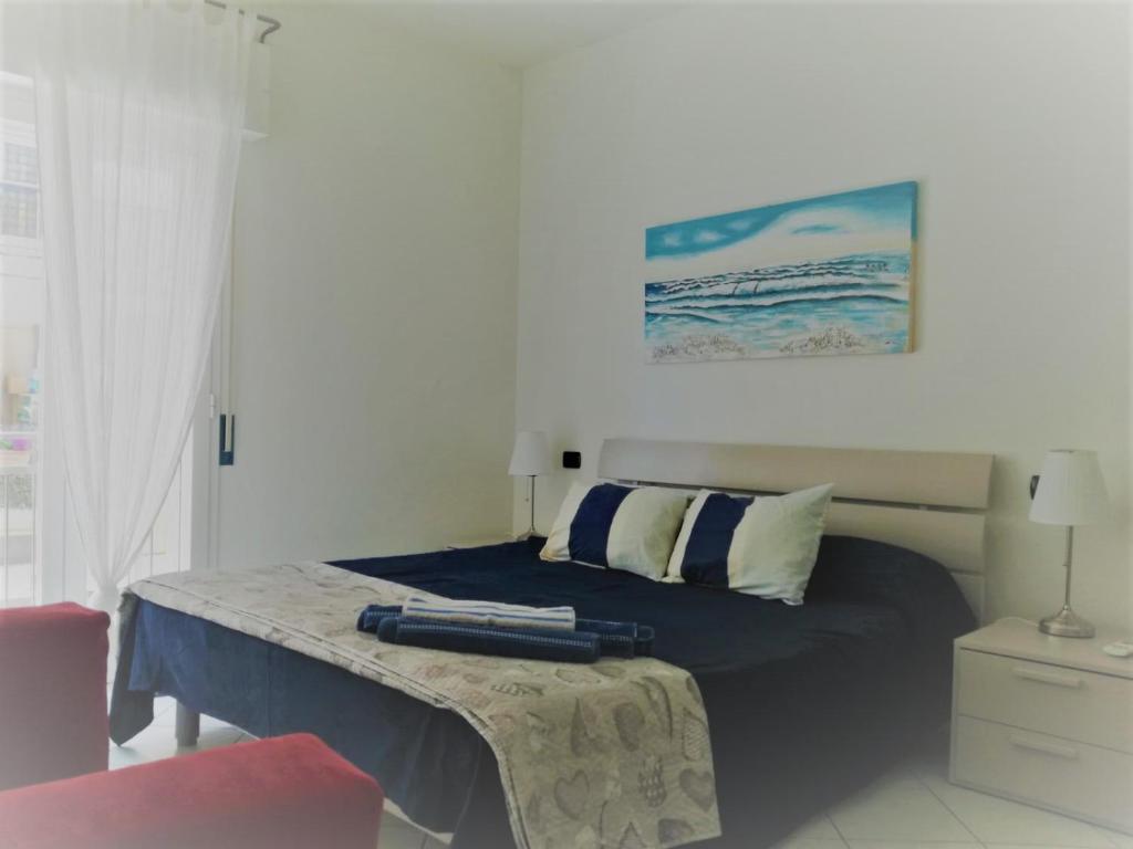 Dormitorio con cama con almohada y pintura en Casa Solemare, en Diano Marina