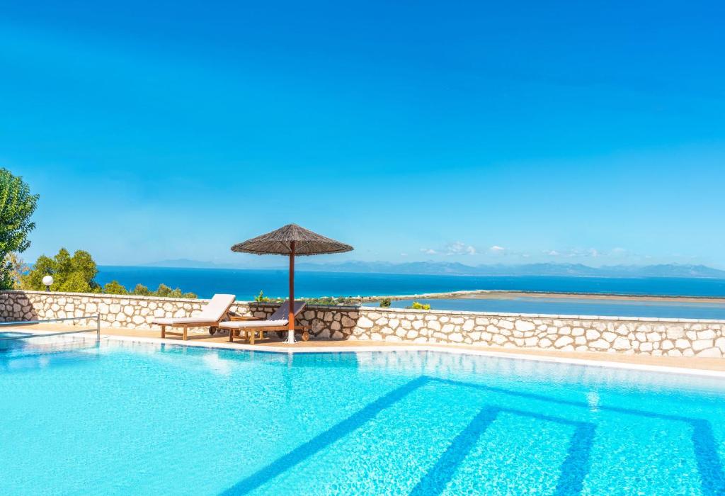 uma piscina com guarda-sol e cadeiras e uma piscina em Niver Luxury Suites em Lefkada