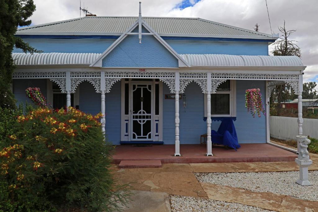 a blue house with a white front porch at Ella's Place in Broken Hill
