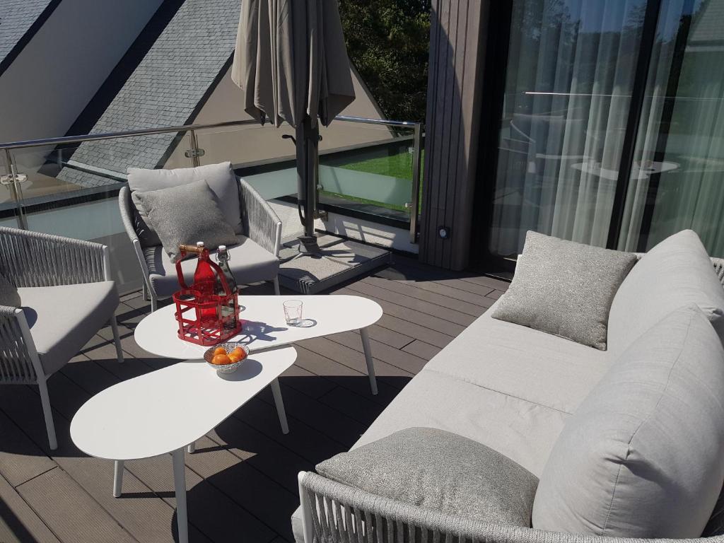a balcony with a white couch and a table at Studio de Lokentaz in Saint-Gildas-de-Rhuys