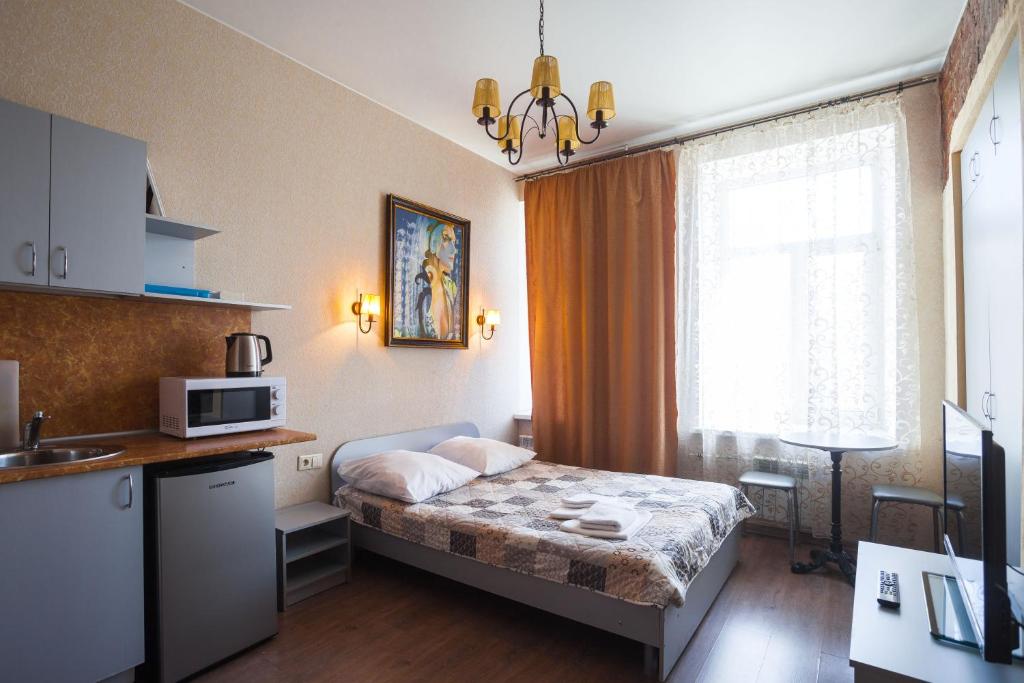 Habitación pequeña con cama y microondas. en LeoHotels На Рижском, en San Petersburgo