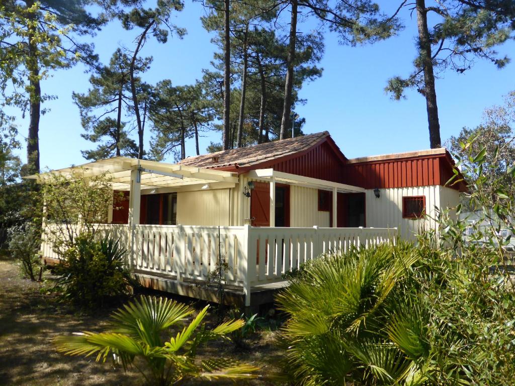 une petite maison avec un toit rouge dans l'établissement Chalet Soulacais avec piscine, à Soulac-sur-Mer