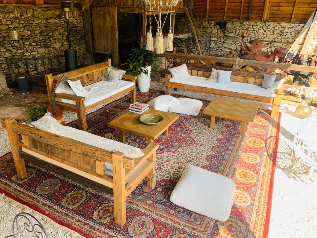 un patio al aire libre con sofás y mesas sobre una alfombra en Chambres d'hôtes Pech Blanc, en Calvignac