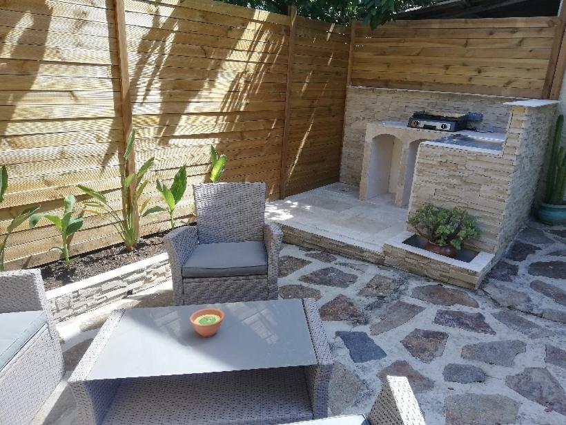 un patio avec une table, des chaises et un grill dans l'établissement Appartement T2 Rez de villa proche bord de mer, au Pradet