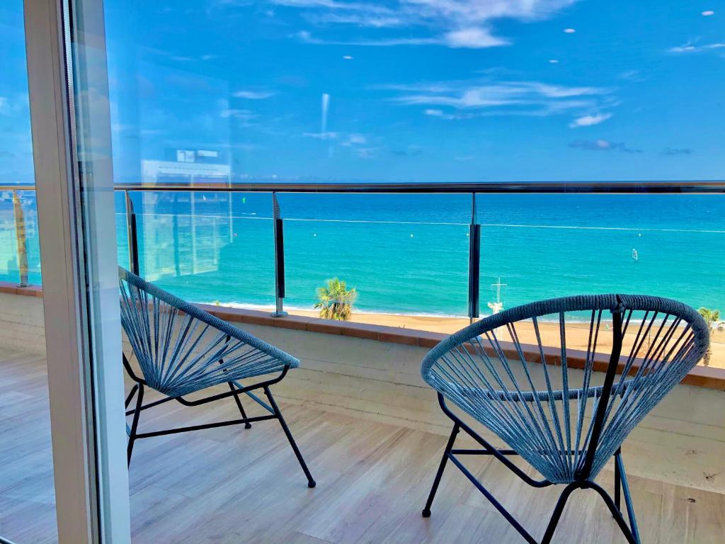 two chairs on a balcony with a view of the ocean at Apartaments Primera Linea Torre Valentina in Sant Antoni de Calonge