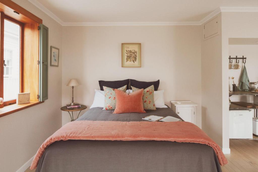1 dormitorio con 1 cama grande con almohadas de color naranja en Room For Two, en Cambridge