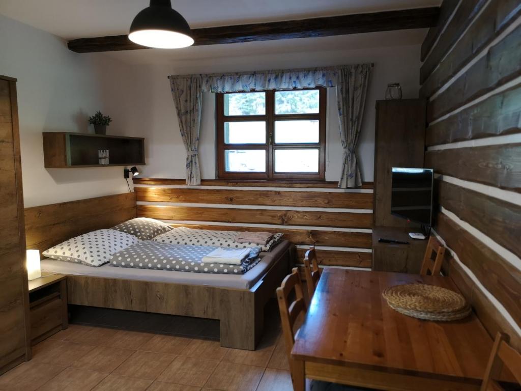 ペツ・ポト・スニェシュコウにあるHorský apartmán 212 - Cihlářkaのベッドルーム1室(ベッド1台、テーブル、窓付)