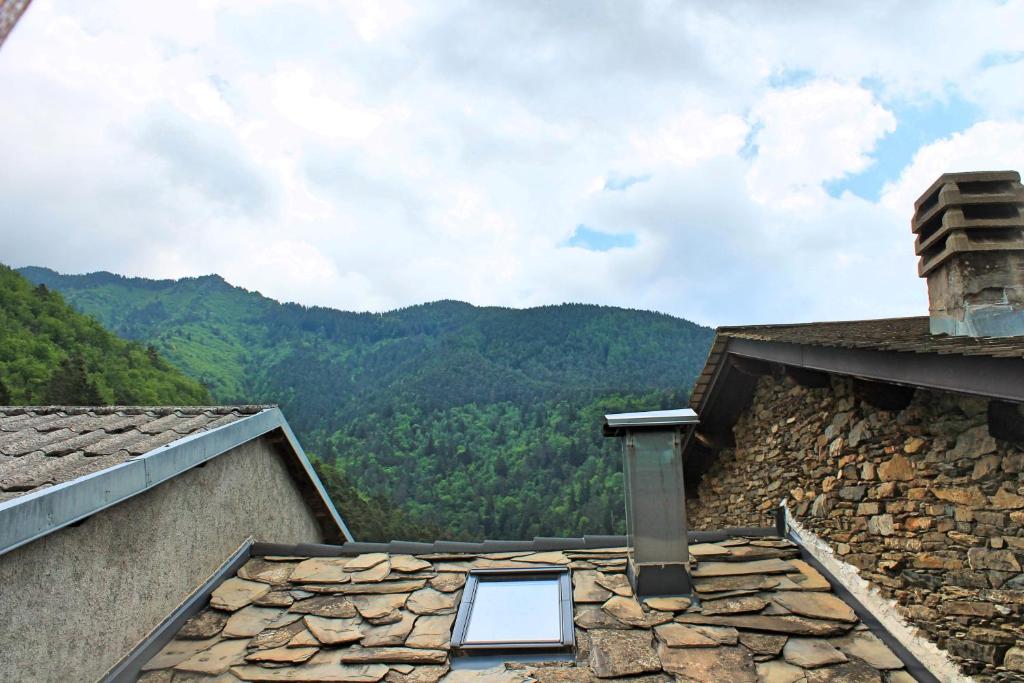 a window on the roof of a building with mountains in the background at CASE CARMELI - Primula in Triora