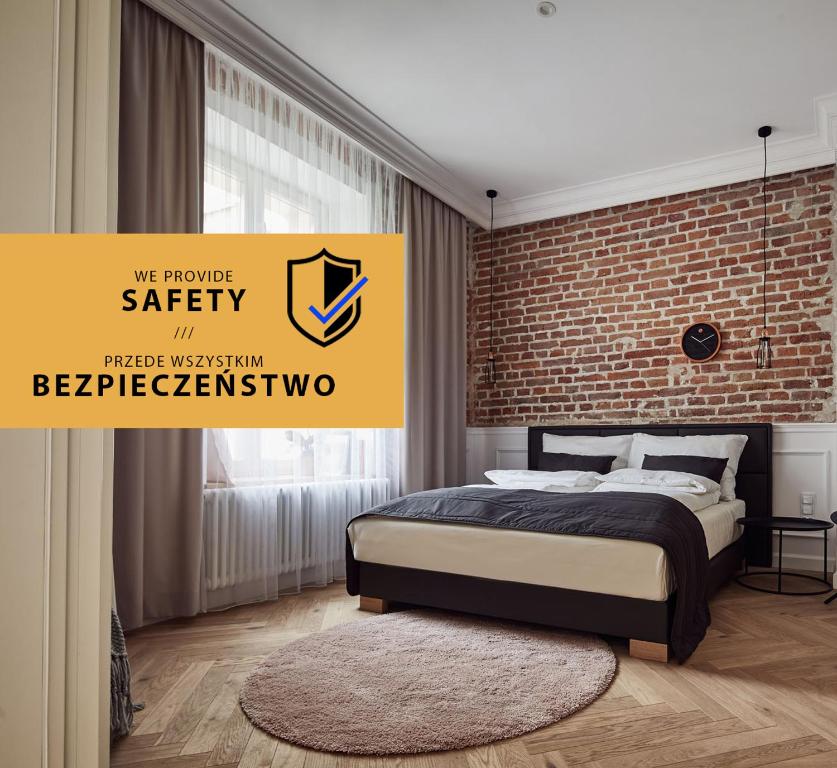 una camera con letto e muro di mattoni di St Agnes Apartments Old Town a Cracovia