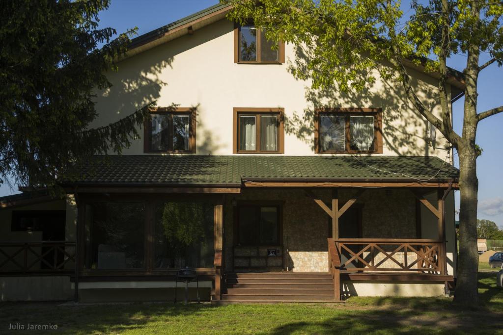 una gran casa blanca con un árbol delante en Leśne Zacisze, en Iława