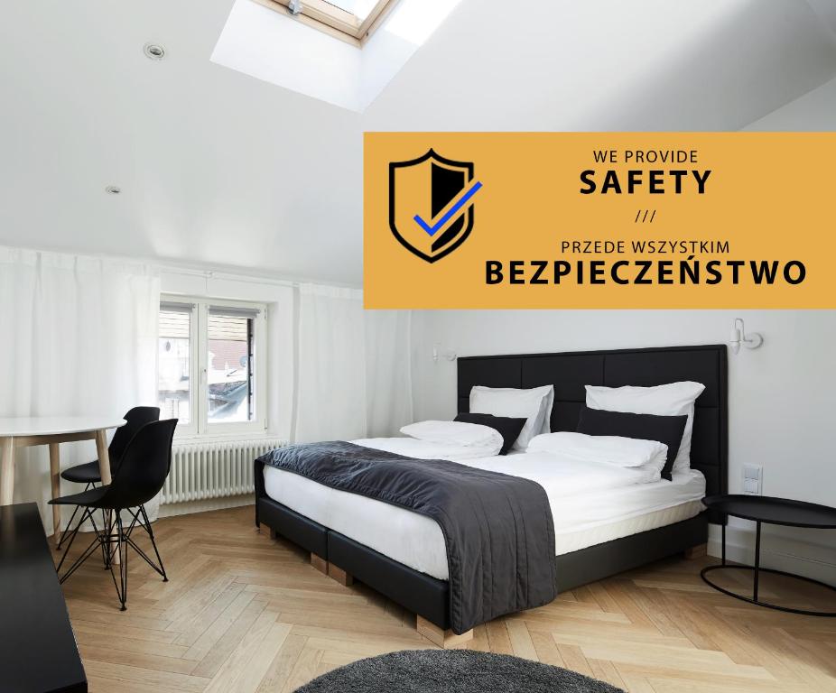 ein Schlafzimmer mit einem Bett und einem gelben Schild an der Wand in der Unterkunft St Agnes Apartments Attic in Krakau