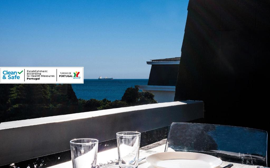 un tavolo con bicchieri e una vista sull'oceano di Cascais-Estoril BEACHFRONT Apartments a Estoril