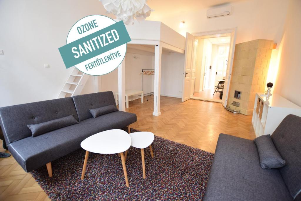 ein Wohnzimmer mit einem Sofa und einem Tisch in der Unterkunft Standard Apartment by Hi5 - Wesselényi 13 in Budapest