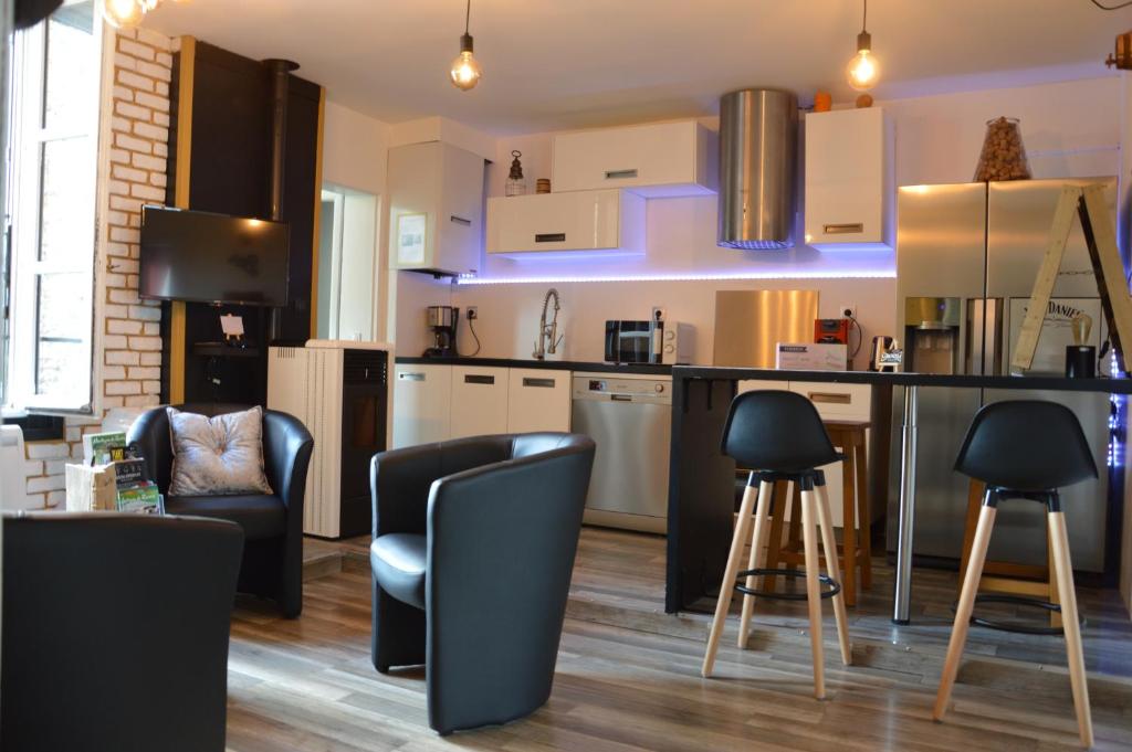 une cuisine avec des chaises noires et un comptoir dans l'établissement Groom Epernay - Jacuzzi & Champagne, à Épernay