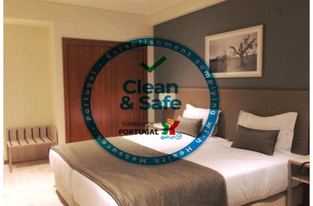 a clock on a bed in a hotel room at Hotel Ponte Sor in Ponte de Sor
