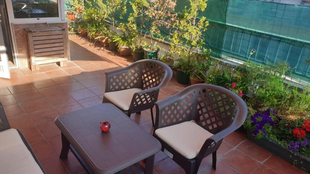 two chairs and a table on a patio with plants at Ático con terraza céntrico Oviedo in Oviedo