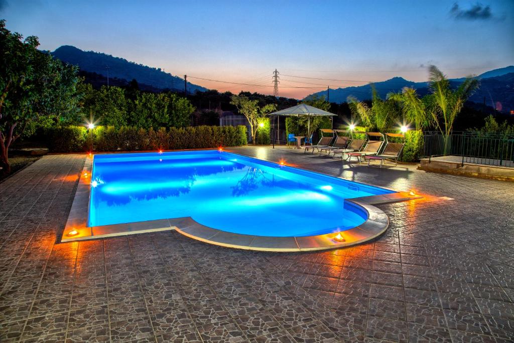 a large blue swimming pool with lights around it at Casa Vacanze Alcantara in Gaggi