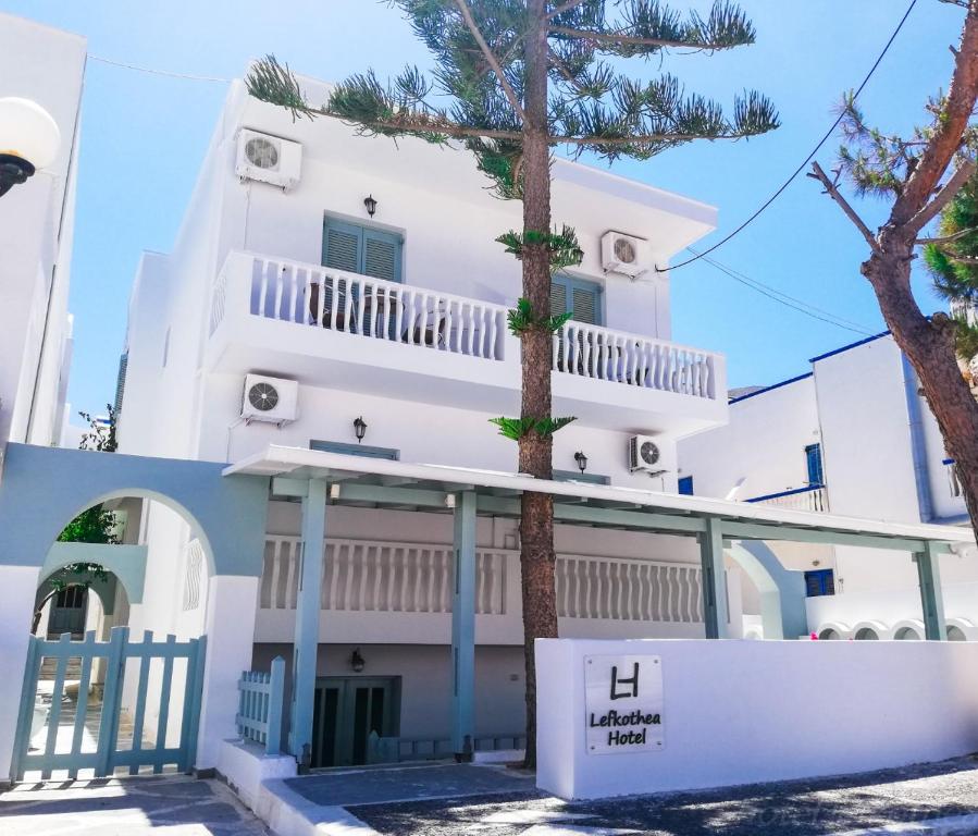 uma casa branca com uma árvore em frente em Lefkothea Hotel em Kamari