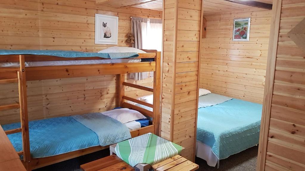 sypialnia z 2 łóżkami piętrowymi w drewnianym domku w obiekcie Ośrodek Wypoczynkowy Regle w Zieleńcu