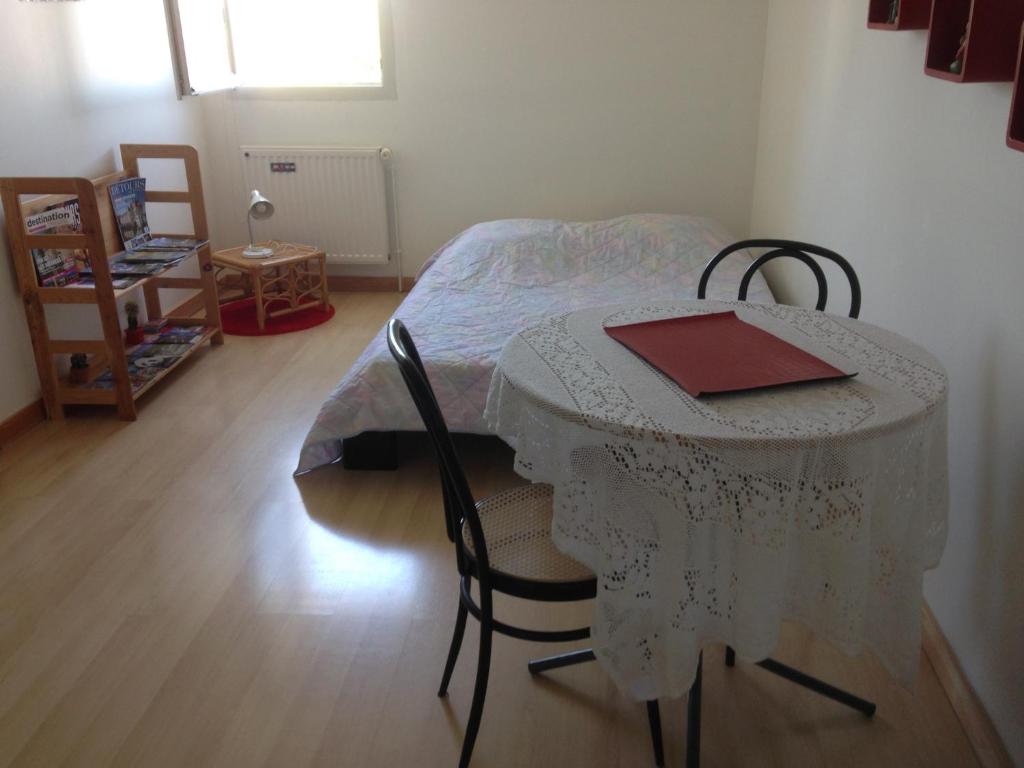 a room with a table and chairs with a bed at Pavillon en Touraine in Savonnières