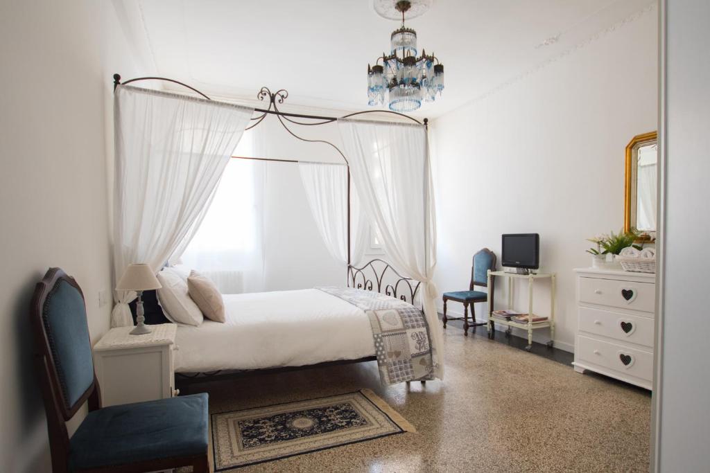 um quarto com uma cama de dossel e uma janela em Biennale Apartments Venice em Veneza