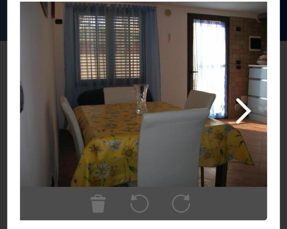 einen Esstisch mit einem gelben Tischtuch darauf in der Unterkunft Appartamento Tavernetta in Lecce