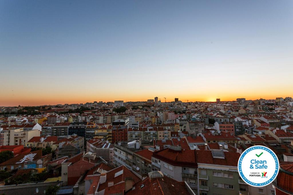 リスボンにあるWHome | Anjos Stylish Apartment #6の夕日を背景に市街を望む