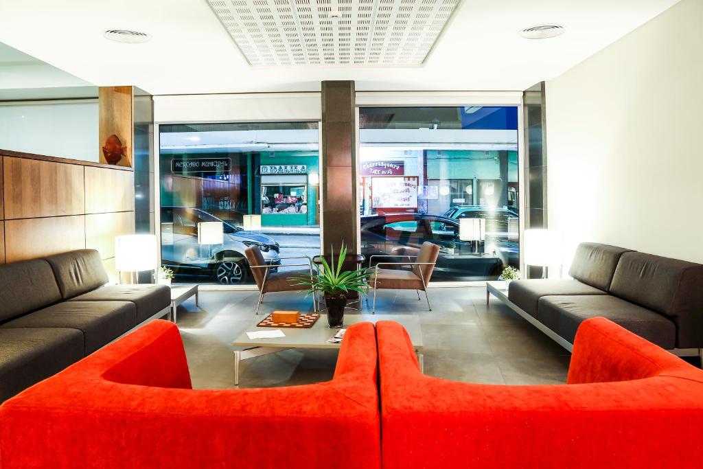 a living room with a red couch and a table at Hotel Praia in Nazaré