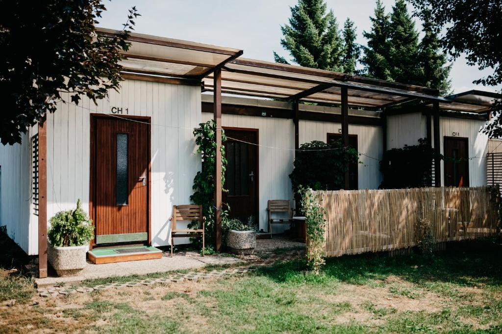 ein kleines weißes Haus mit einer Holztür in der Unterkunft Camp Alpa in Ostrovačice