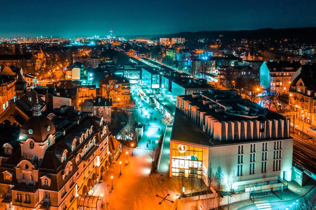 a view of a city at night with lights at Hotel Molo in Sopot