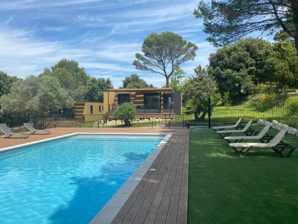 una piscina con sillas y una casa en Les Troglodytes du Ventoux, en Bollène