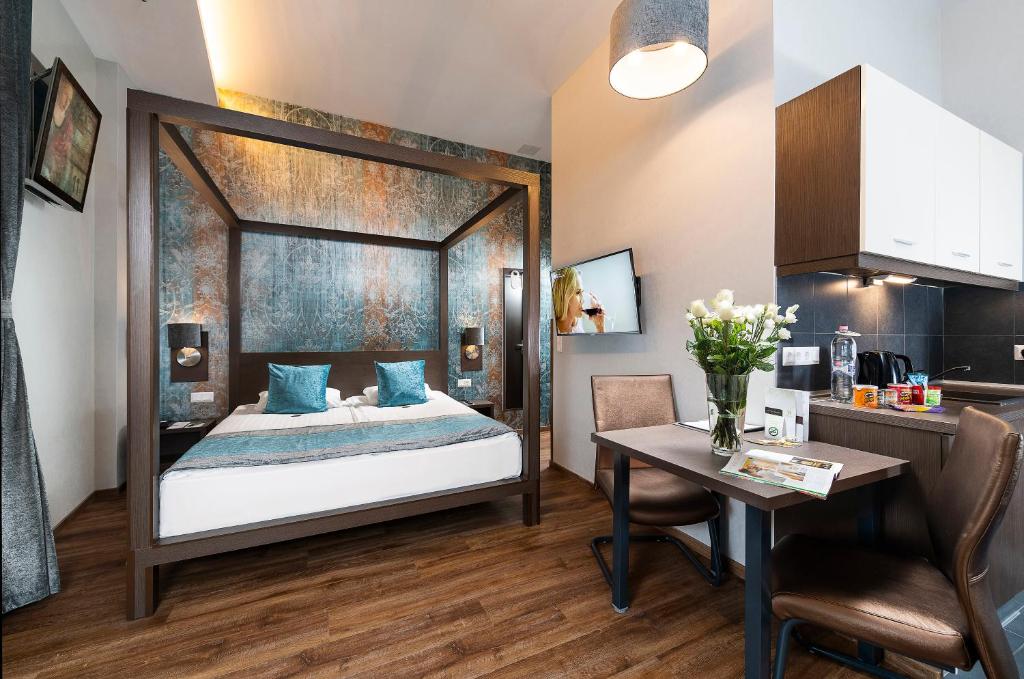 a bedroom with a canopy bed and a table at Opera Garden Hotel & Apartments in Budapest